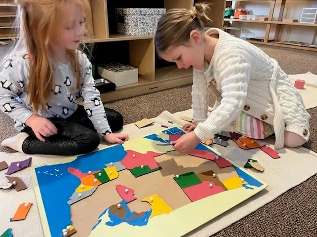 Children working with a Montessori map puzzle
