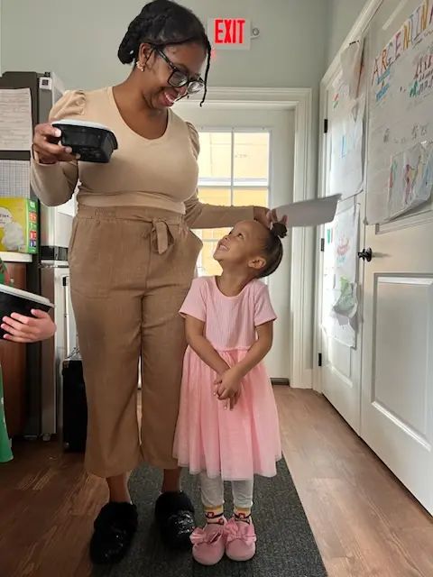 Educator greeting a child at school